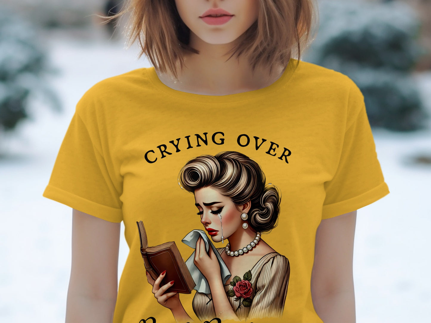 Yellow t-shirt with "Crying Over" text and illustration of a crying woman reading a book.