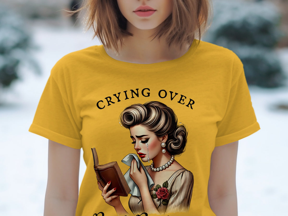 Yellow t-shirt with "Crying Over" text and illustration of a crying woman reading a book.