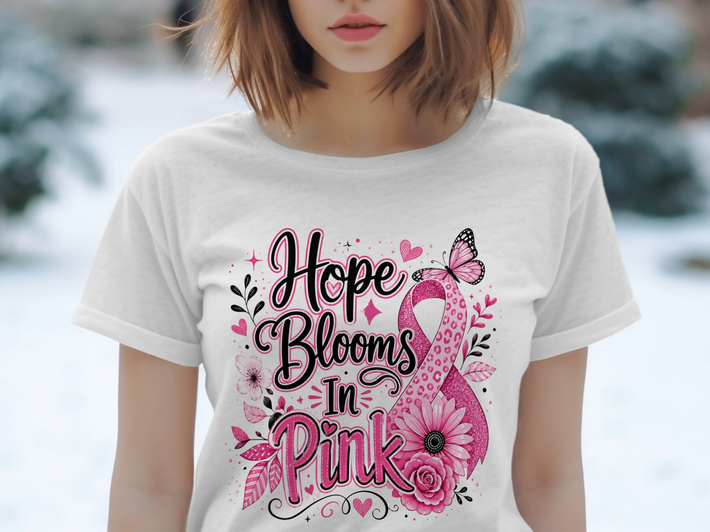White t-shirt with "Hope Blooms In Pink" text and pink ribbon design.