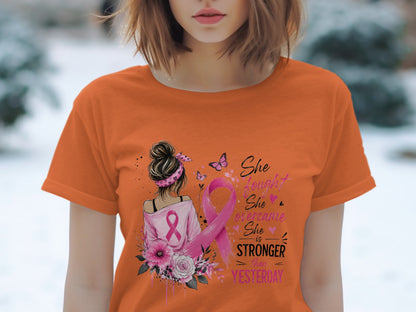 Orange t-shirt with "She fought, she overcame, she is stronger than yesterday" text and pink ribbon.