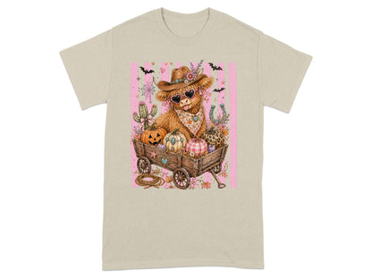 Cowboy Highland cow in wagon with pumpkins, cactus, and horseshoe graphic.