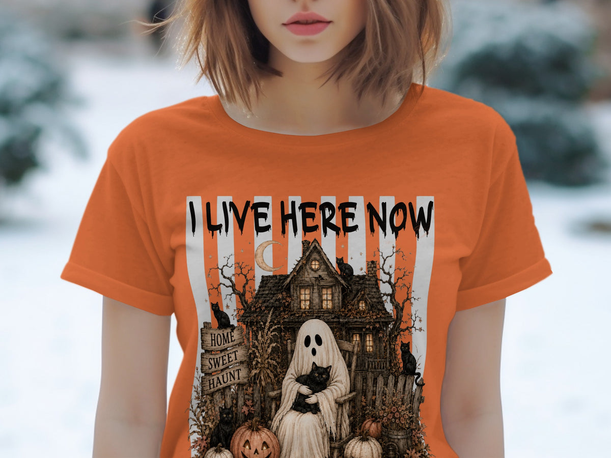 Orange t-shirt with "I LIVE HERE NOW" and haunted house, ghost, cats, and pumpkins graphic.