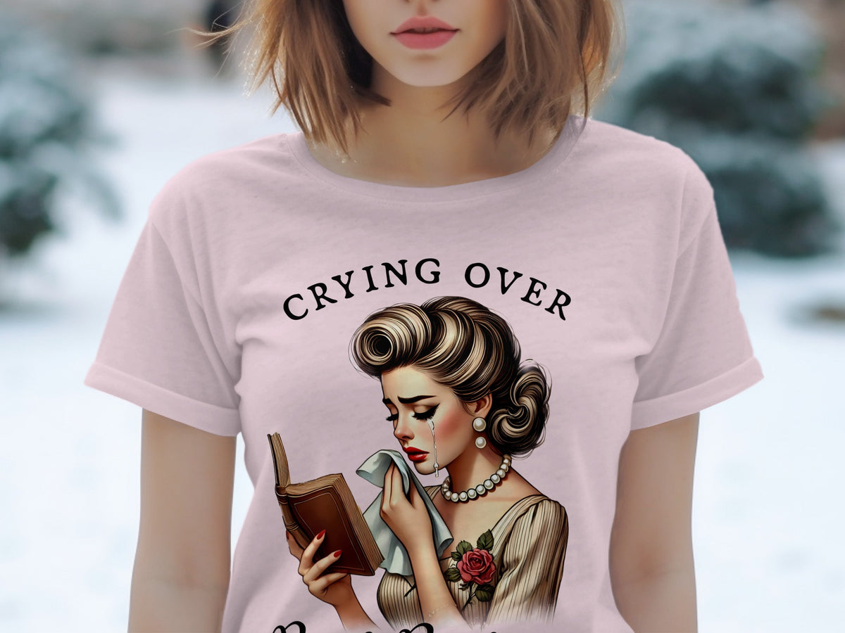 T-shirt graphic: Woman crying over a book, text reads "Crying Over".
