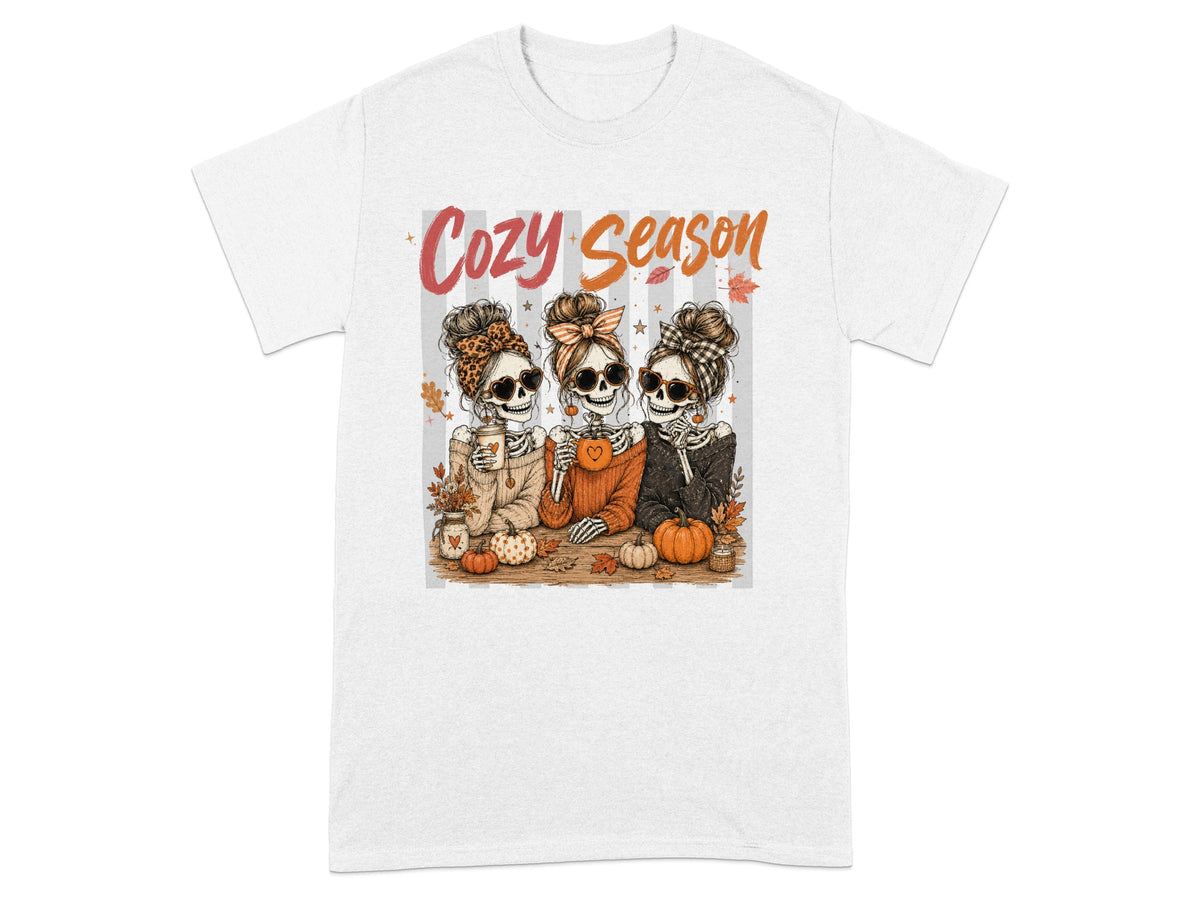 Three skeleton women with messy buns and sunglasses celebrate "Cozy Season" with pumpkins.