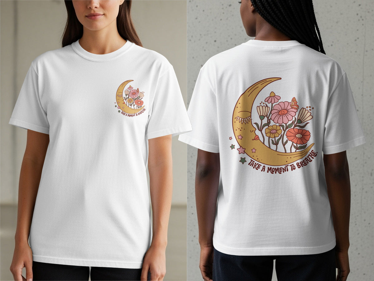 White t-shirt with crescent moon, flowers, and "Take a moment to breathe" text.