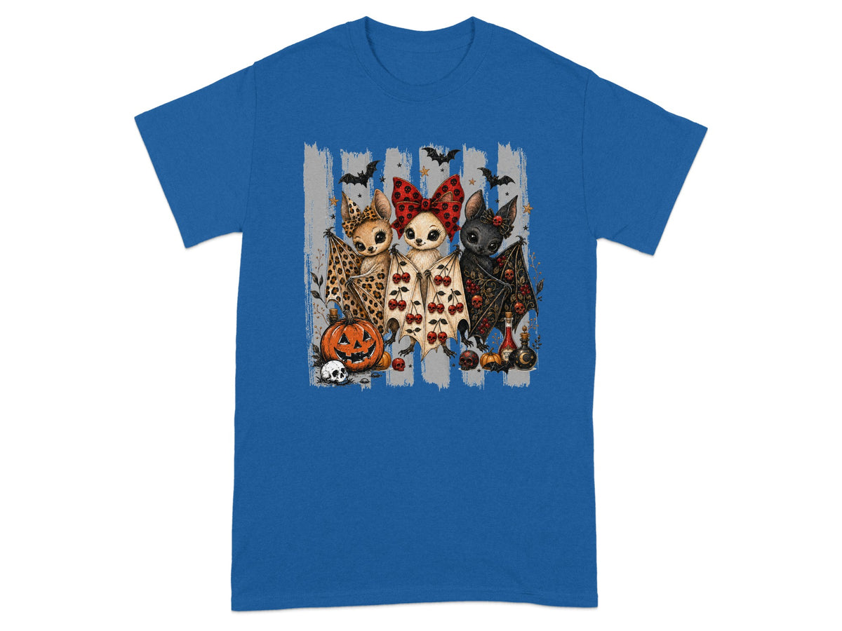 Three bats with Halloween decorations stand on a blue t-shirt.