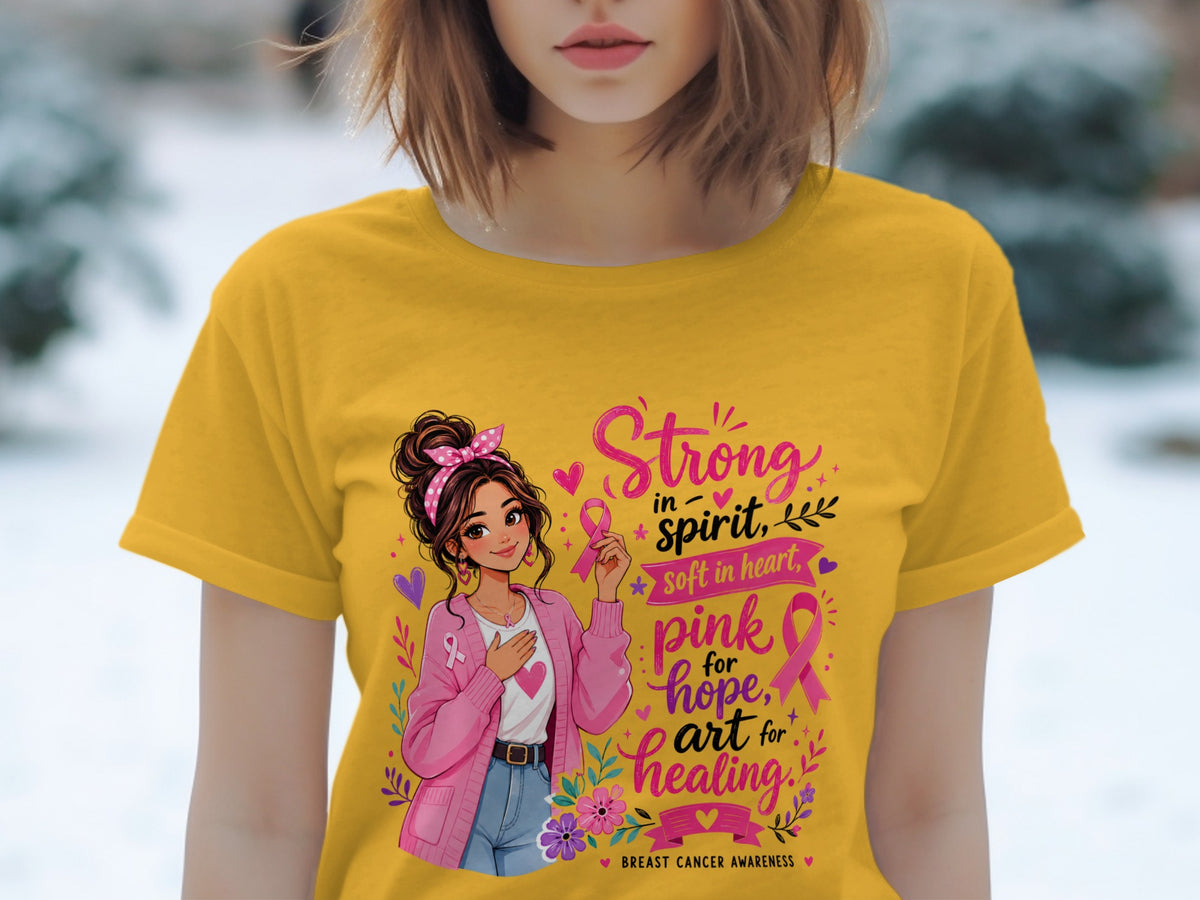 Yellow t-shirt with graphic: girl holding pink ribbon, "Strong in spirit, soft in heart" and "pink for hope, art for healing".