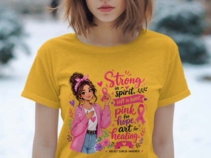 Yellow t-shirt with graphic: girl holding pink ribbon, "Strong in spirit, soft in heart" and "pink for hope, art for healing".