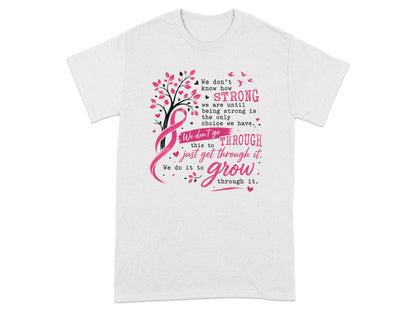 White t-shirt with pink ribbon, tree, and quote about strength and growing through challenges.