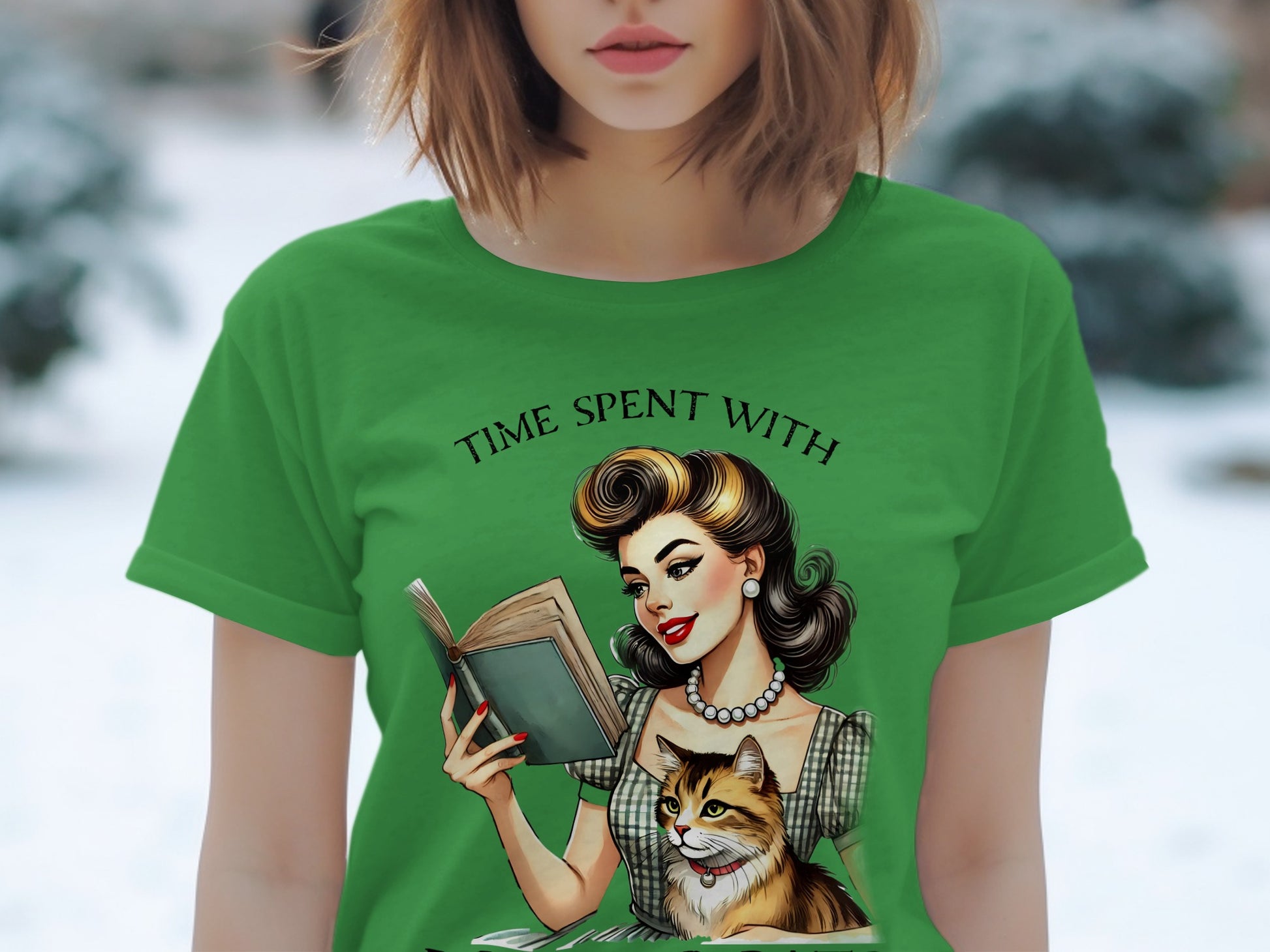 Green t-shirt with retro illustration of woman reading with cat, "Time Spent With" text.