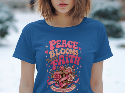 Blue t-shirt with "Peace Blooms Through Faith" and a cross with roses and a ribbon.