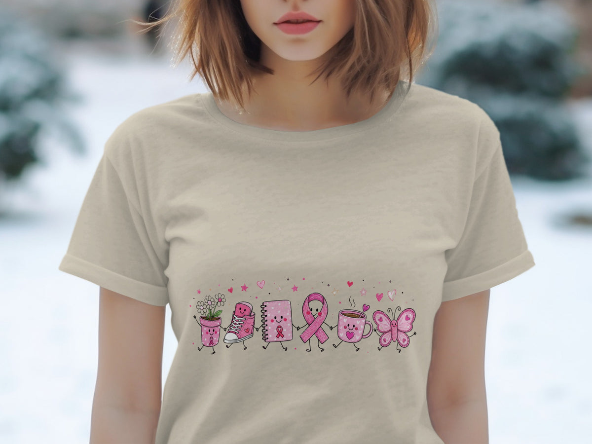 Tan t-shirt with a cartoon line of pink breast cancer awareness ribbon, flower pot, shoe, notebook, mug, and butterfly.