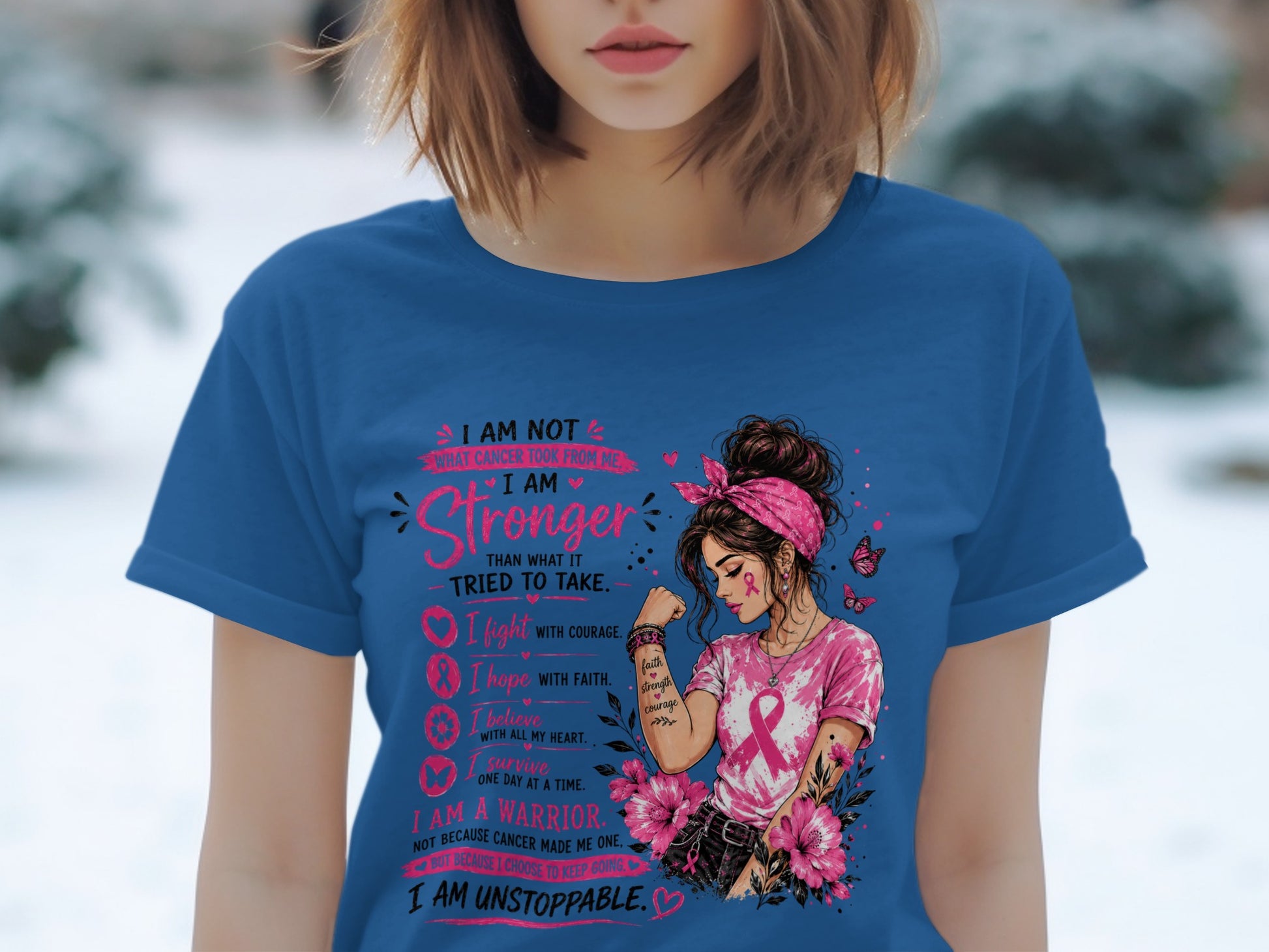 Woman in blue t-shirt with breast cancer awareness design and inspirational text.