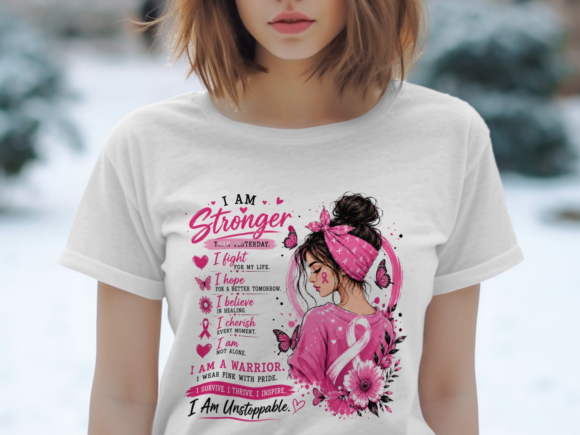 White t-shirt with pink text and graphics featuring a woman, butterflies, and breast cancer awareness ribbon.