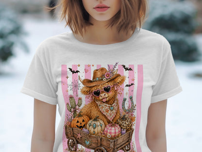Highland cow in cowboy hat and heart sunglasses with pumpkins in wagon on pink stripes.