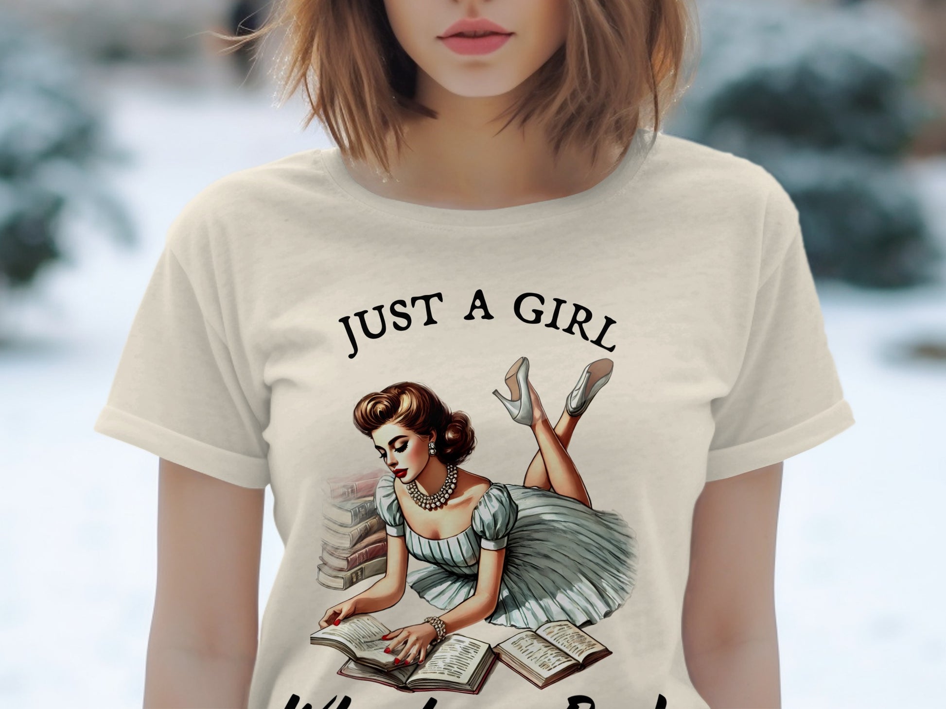 T-shirt with "JUST A GIRL" text and vintage illustration of woman reading books.