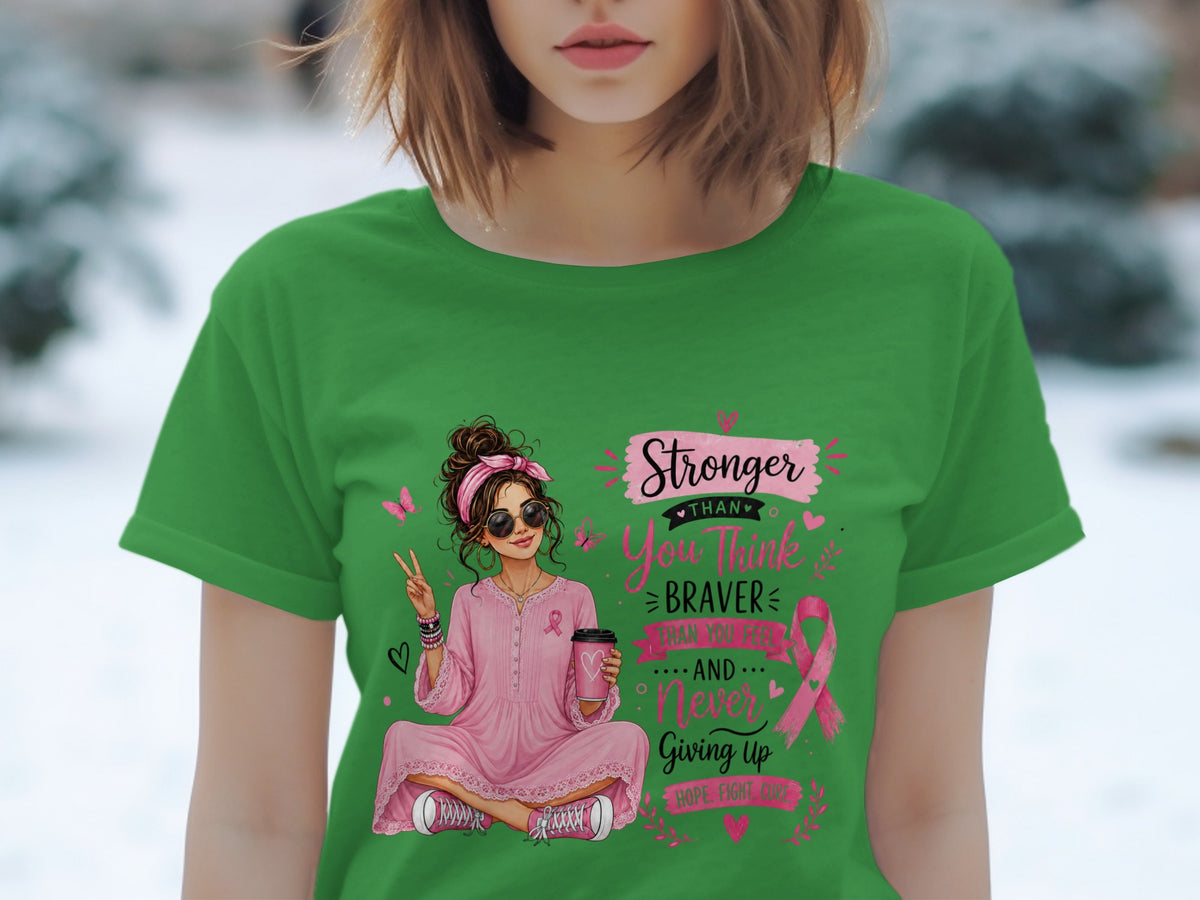 Green t-shirt with a graphic of a woman holding coffee and text about strength and breast cancer awareness.