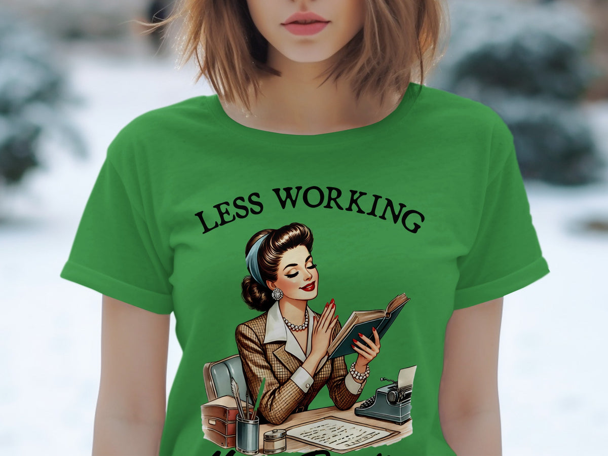 Green t-shirt with illustration of woman reading book with text "LESS WORKING"