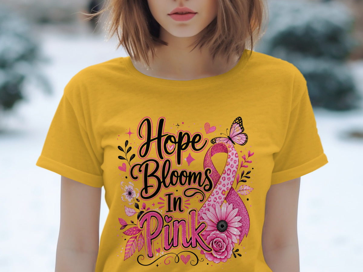 Yellow t-shirt with pink ribbon graphic and text "Hope Blooms In Pink".
