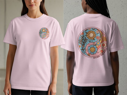 Pink t-shirt with yin-yang design featuring smiling flowers and text "BALANCE OVER HUSTLE".