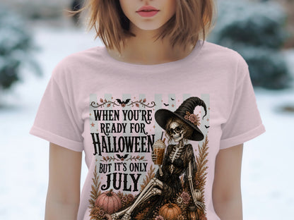 Skeleton witch with drink, pumpkins, and text "When you're ready for Halloween but it's only July."