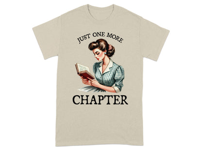 Light beige t-shirt with retro illustration and text "JUST ONE MORE CHAPTER".