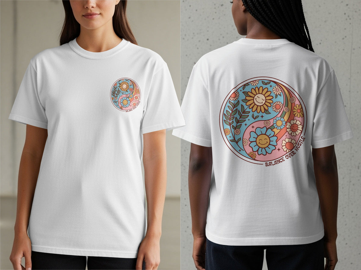 White t-shirt with a yin-yang design featuring smiling flowers and the text "BALANCE OVER HUSTLE."