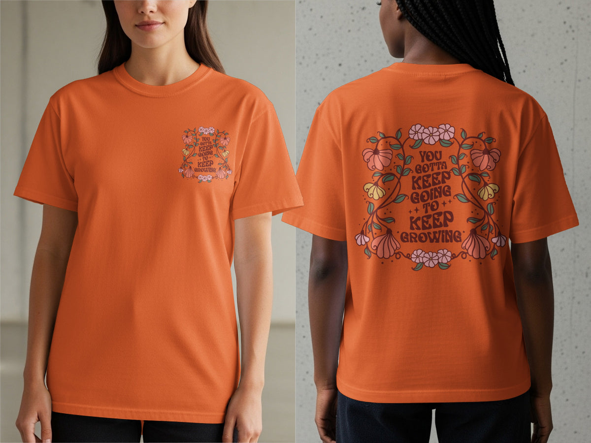 Orange t-shirt with floral design and text "You gotta keep going to keep growing".