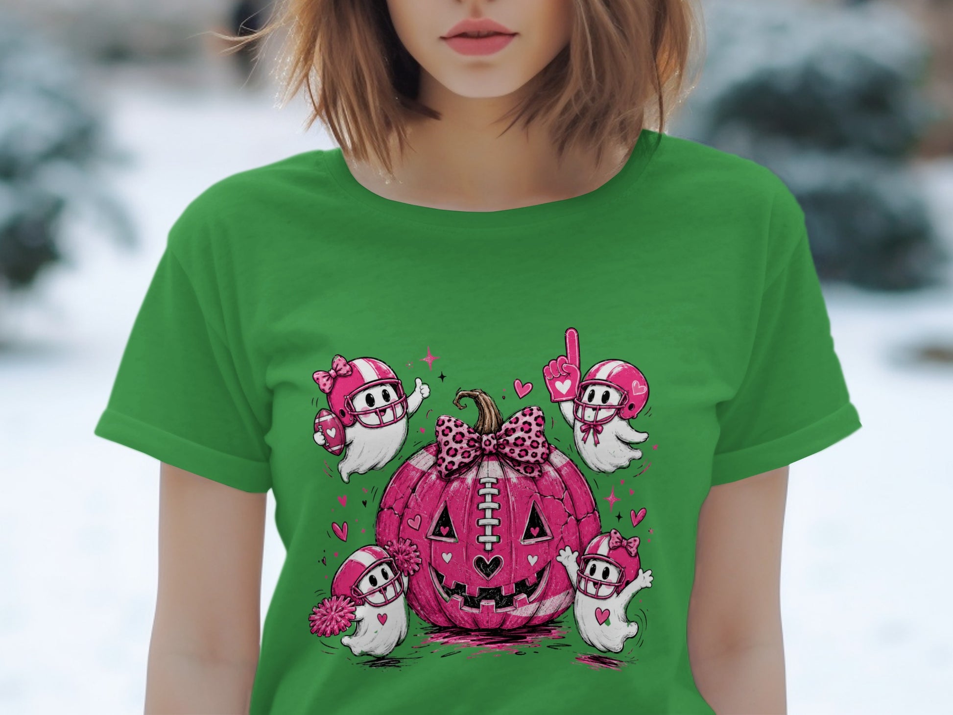 Green t-shirt with pink football-themed ghosts surrounding a pink jack-o'-lantern.