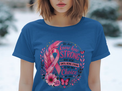 Blue t-shirt with pink breast cancer ribbon, feathers, flowers, butterflies, and empowering text.
