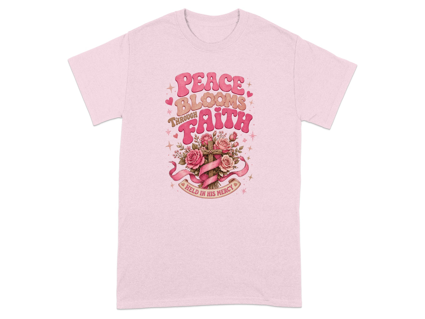 Pink t-shirt with "Peace Blooms Through Faith Held In His Mercy" text and floral cross graphic.