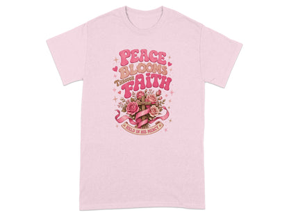 Pink t-shirt with "Peace Blooms Through Faith Held In His Mercy" text and floral cross graphic.