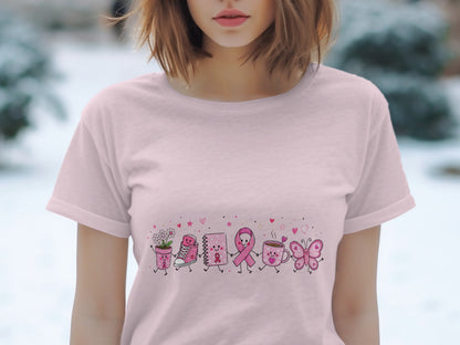 Pink t-shirt with a cartoon line of pink ribbon, shoe, notebook, coffee cup, and butterfly.