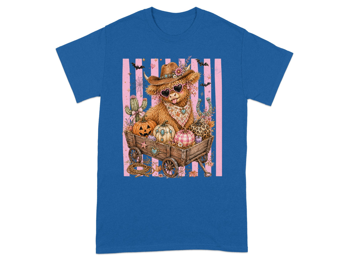 Highland cow in cowboy hat and heart sunglasses in a wagon full of pumpkins.