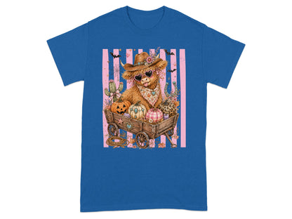 Highland cow in cowboy hat and heart sunglasses in a wagon full of pumpkins.