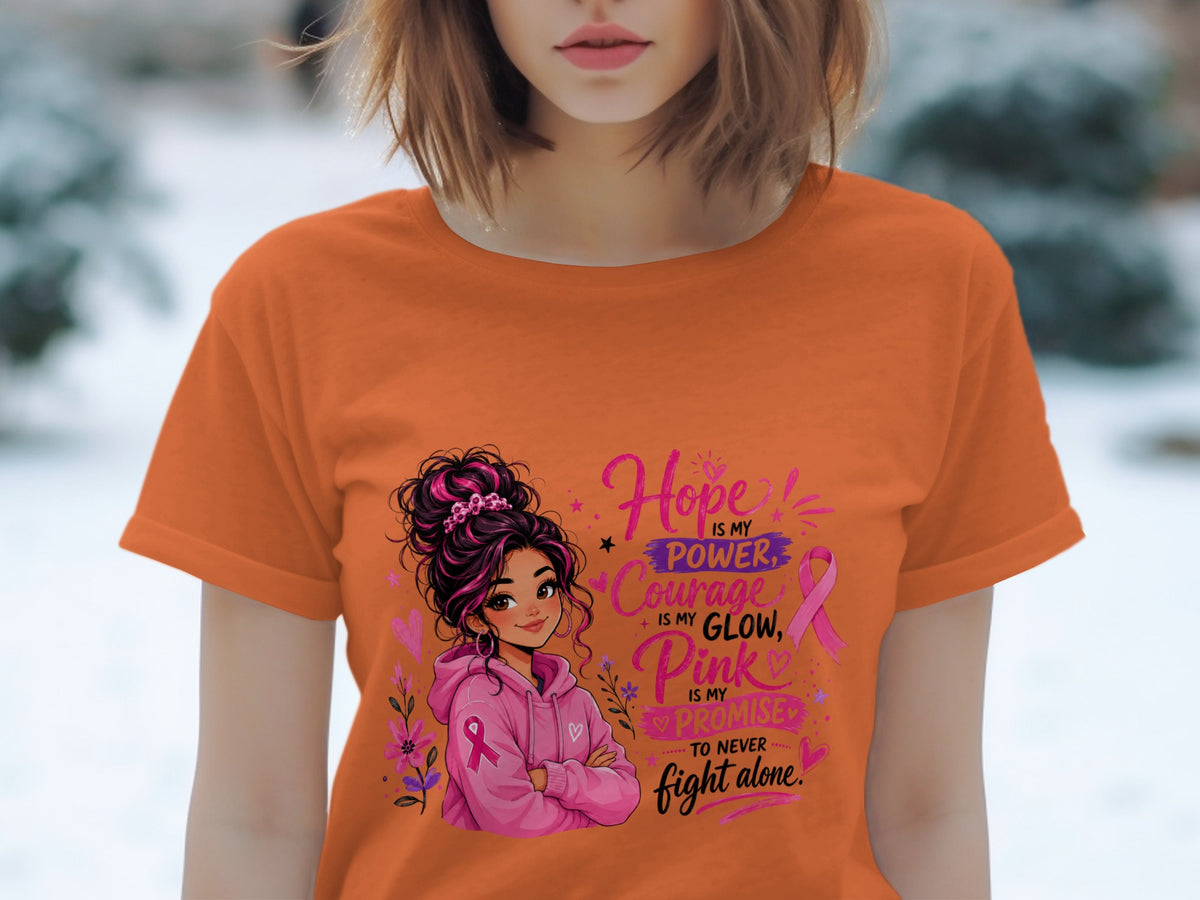 Orange t-shirt with illustration of girl and text "Hope is my power, courage is my glow, Pink is my promise to never fight alone."