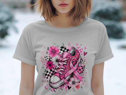 Pink sneaker with ribbon and flowers on a light gray t-shirt.