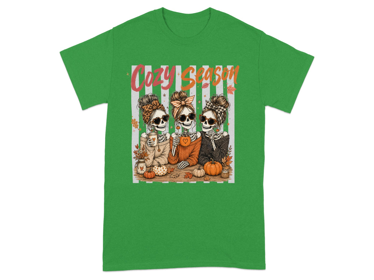 Three skeletons in sunglasses and headbands enjoying "Cozy Season" with pumpkins.