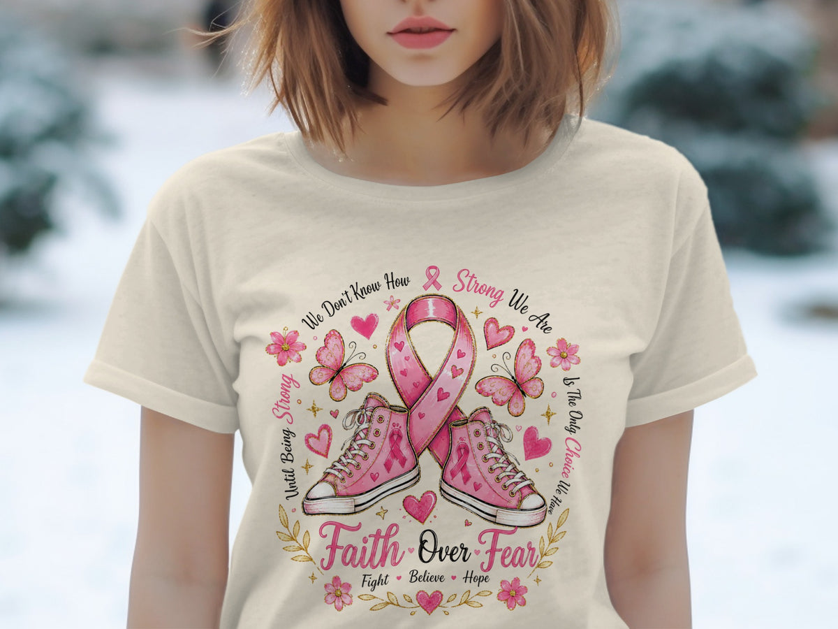 Pink ribbon, sneakers, butterflies, flowers, and text about strength and faith on a t-shirt.