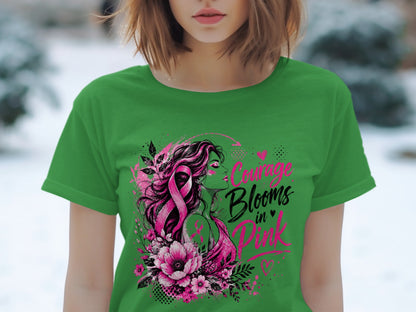 Green t-shirt with pink design featuring woman, flowers, and "Courage Blooms in Pink" text.