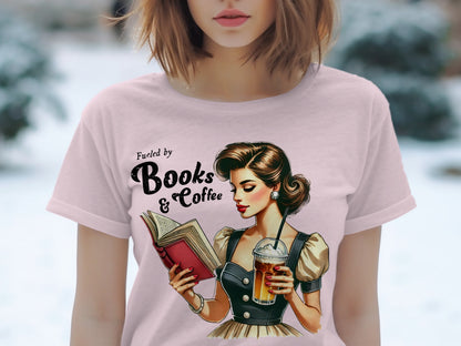 Pink t-shirt with "Fueled by Books & Coffee" text and retro illustration.