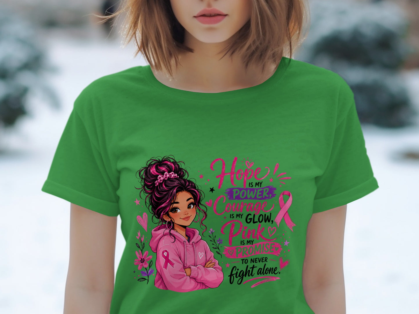 Green t-shirt with illustration of a girl and text about hope, power, courage, glow, pink, and promise.