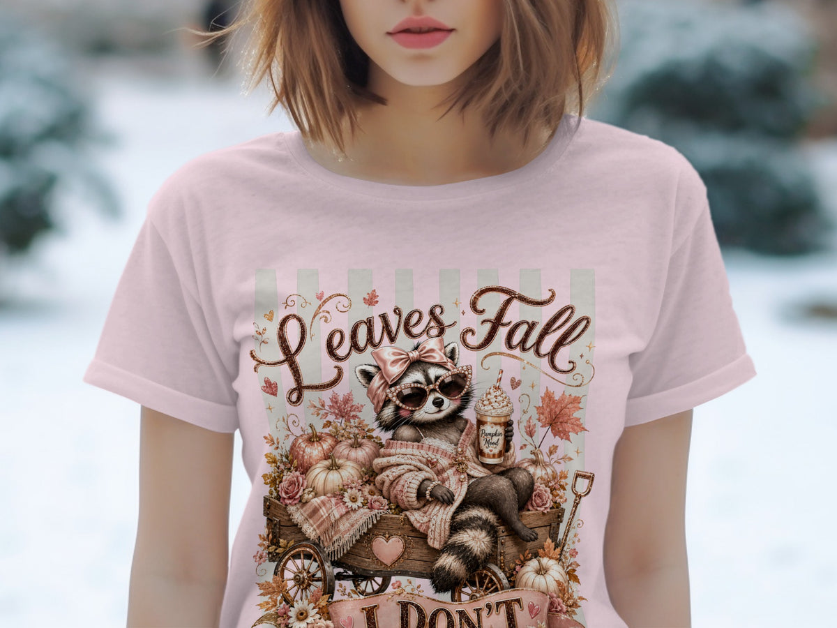 Raccoon with pumpkin spice latte and pumpkins on a cart, text "Leaves Fall".