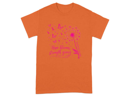 Orange t-shirt with pink dandelion, butterflies, ribbons, and text "Hope blooms, strength grows".