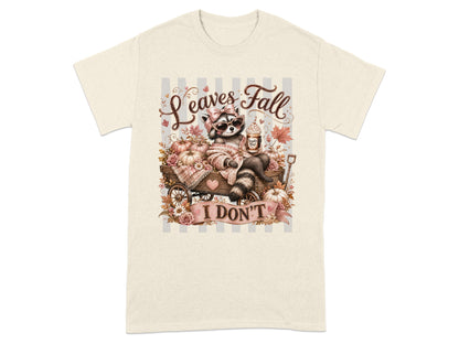 Raccoon in cart with pumpkins, holding drink, text "Leaves Fall I DON'T".