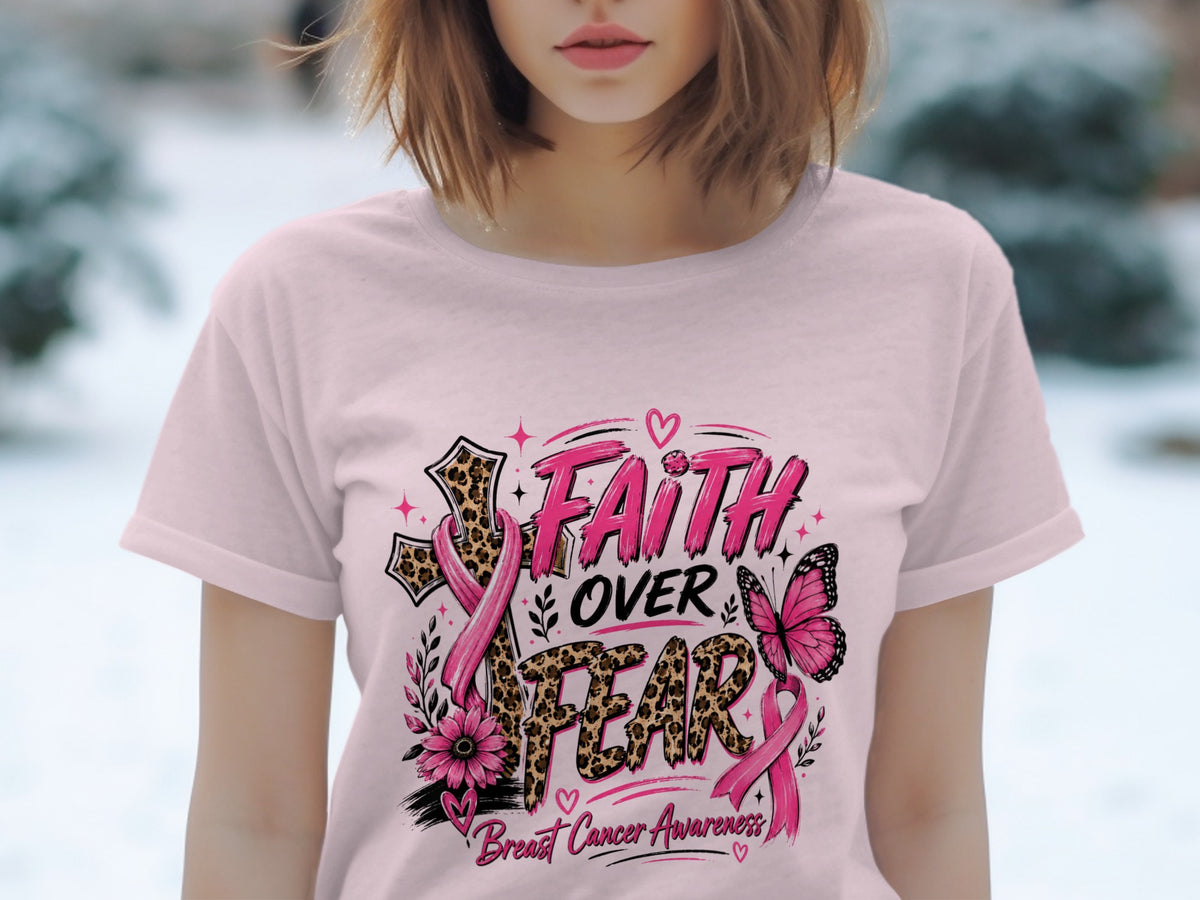 Pink t-shirt with "Faith Over Fear" text, breast cancer ribbons, cross, butterfly, and flower.