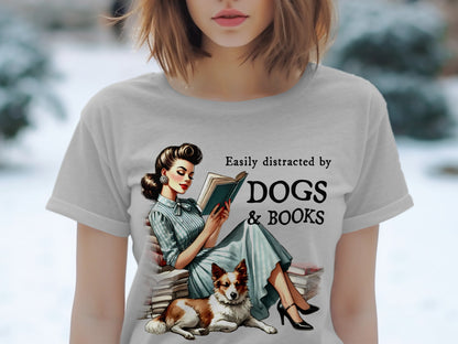 Graphic art on shirt: woman reading books with dog, text "Easily distracted by DOGS & BOOKS".