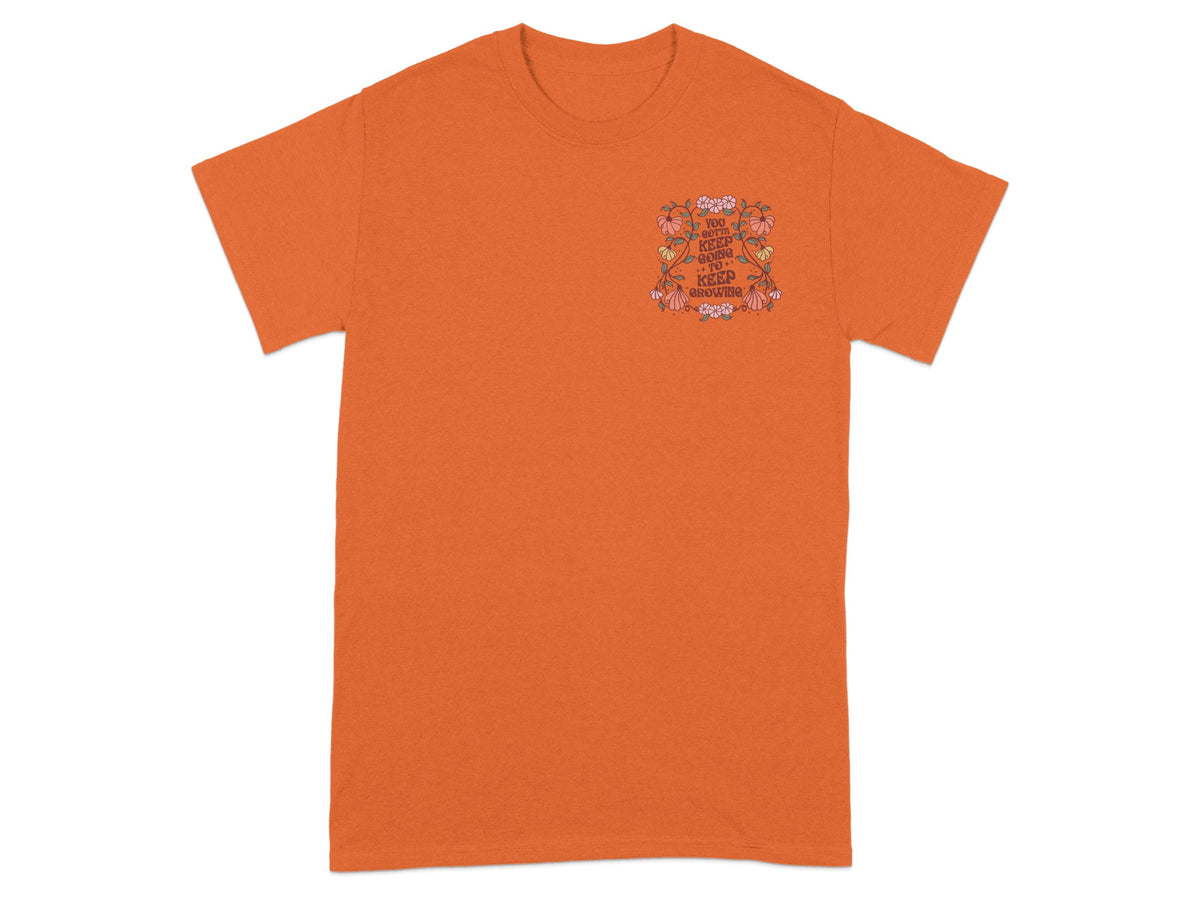Orange t-shirt with floral design and text "You gotta keep going to keep growing."