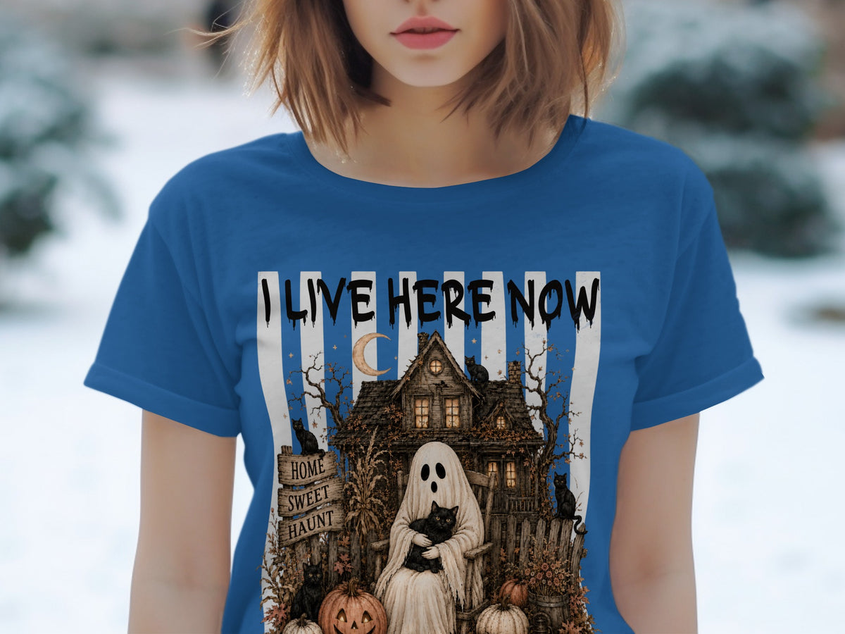 Ghost with cat, haunted house, pumpkins, and black cats on a blue shirt with "I LIVE HERE NOW".