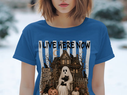 Ghost with cat, haunted house, pumpkins, and black cats on a blue shirt with "I LIVE HERE NOW".